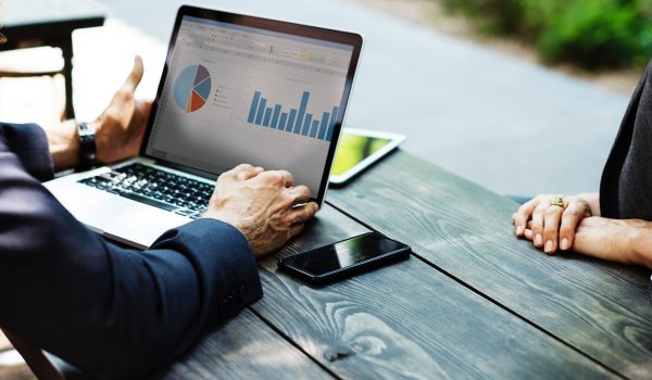 Photo of person's hands while viewing accounting charts on laptop