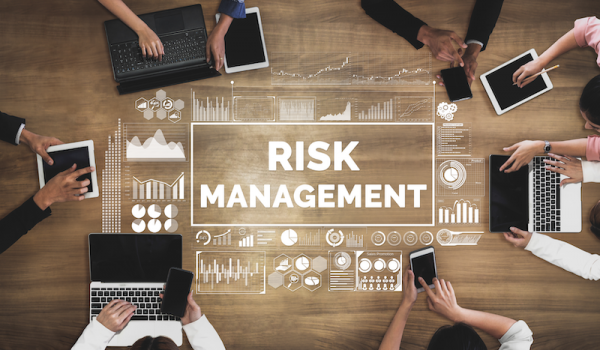 Risk Management written on table with laptops